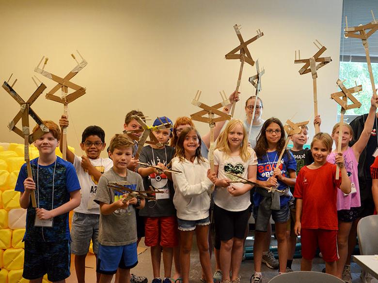 A group of kids showing off their projects at Kids' College